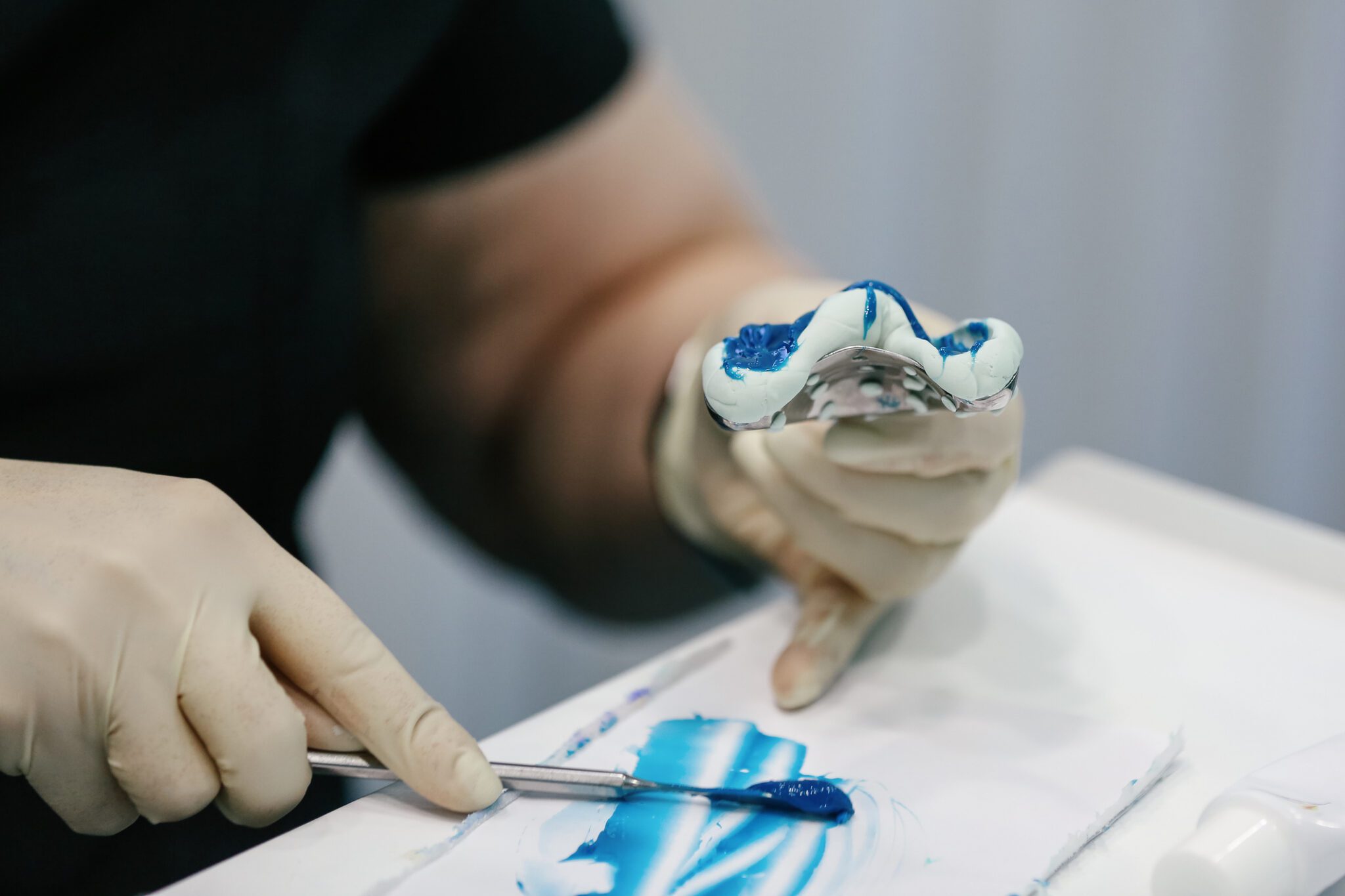 Medicine And Doctor's Issue. Cropped Hands Adult Woman Wearing Protective Gloves Making Dental Prosthesis. Real Life, Ambient Light, Copy Space