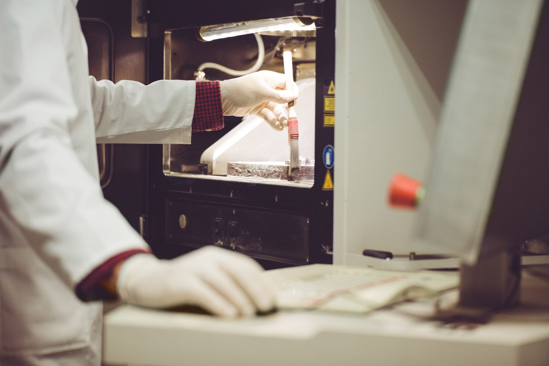 Worker brushing powder off 3D powder printer